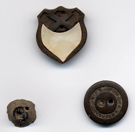 Enlarged image of Shield made from hard rubber button and inlaid with silver cross and mother of pearl. Button marked Goodyear S P. (R. Ibos Collection)